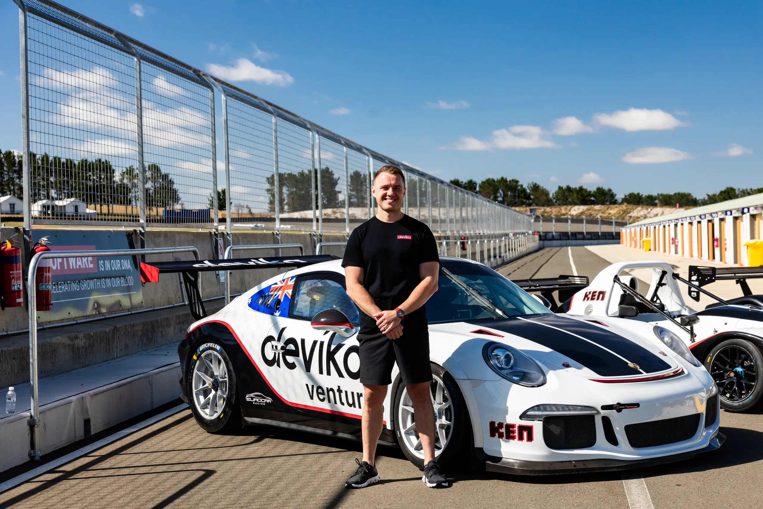 Ken Kencevski beside a Devika Ventures race car