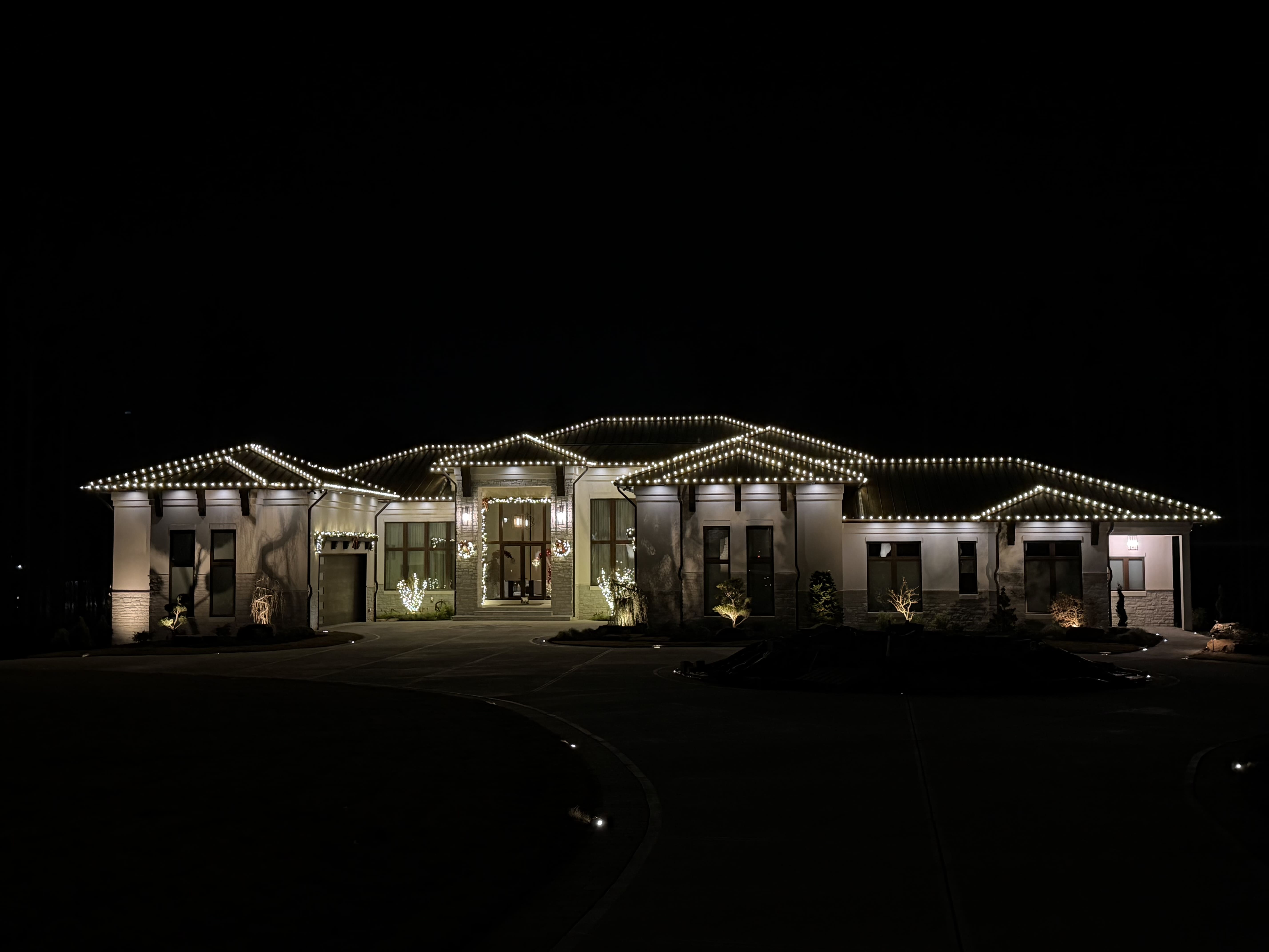 House decorated with Christmas lights at night.