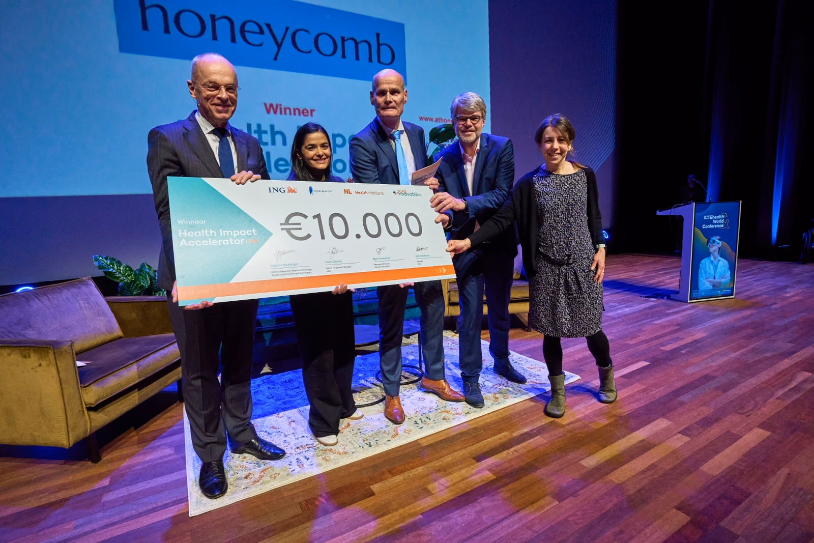 De winnaar poseert met de cheque