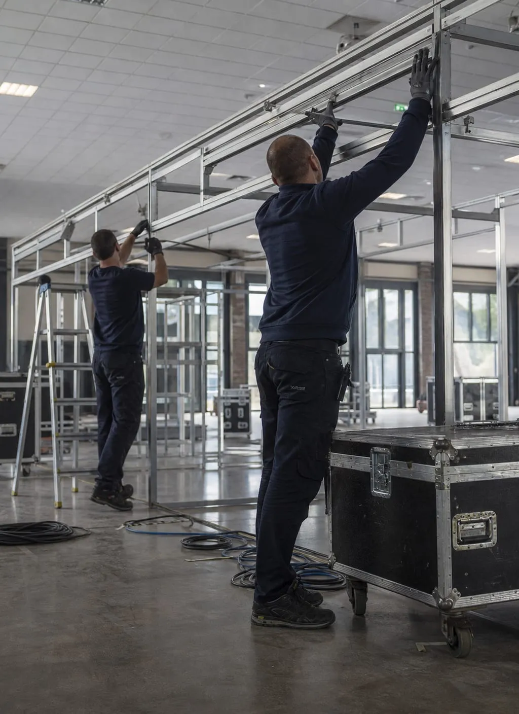 Techniciens montant une structure de stand avant l’ouverture