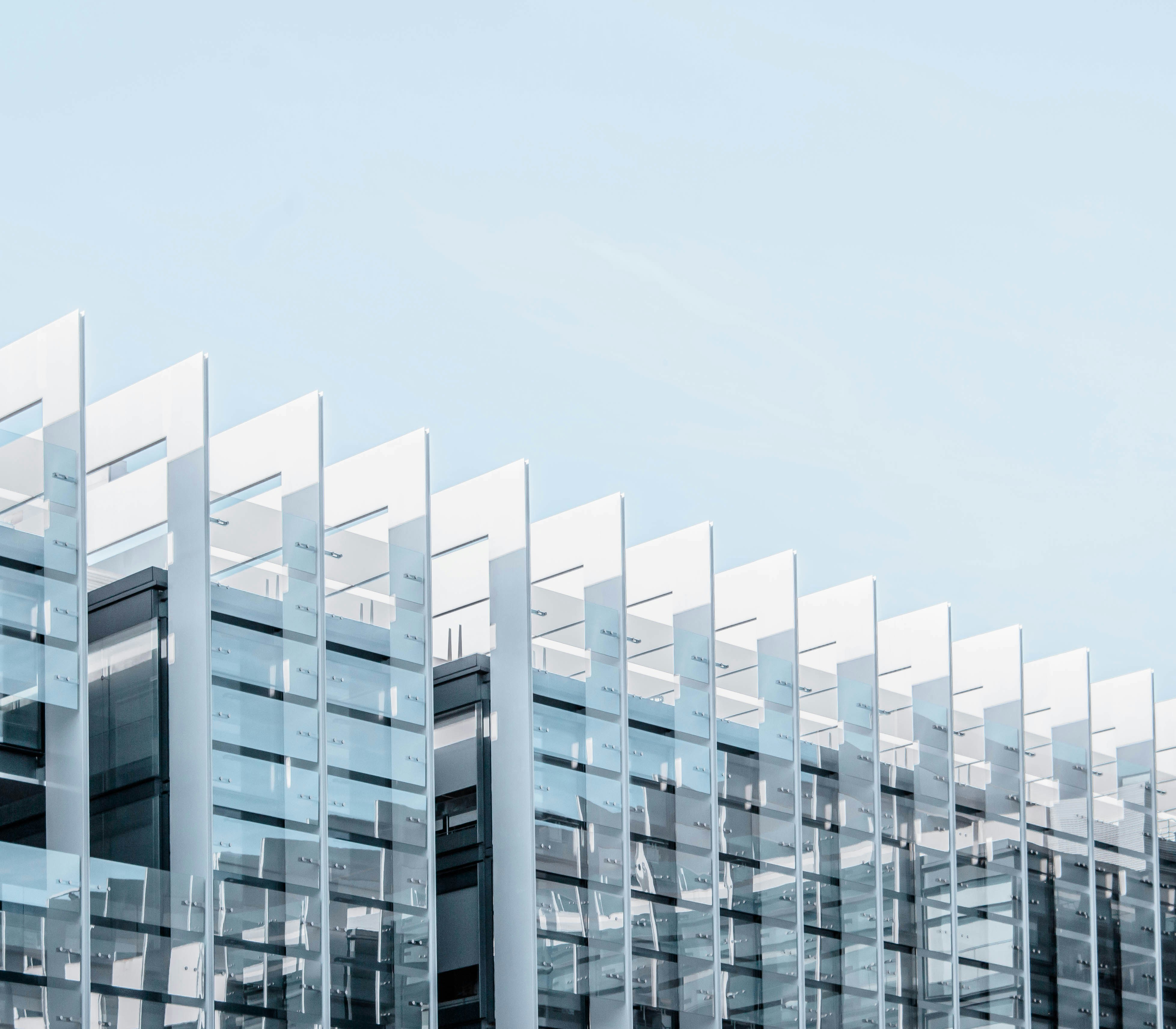 Modern building facade with sharp lines against a bright sky
