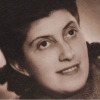 Portrait en noir et blanc d'une femme souriante aux cheveux foncés courts, regardant légèrement vers la droite.