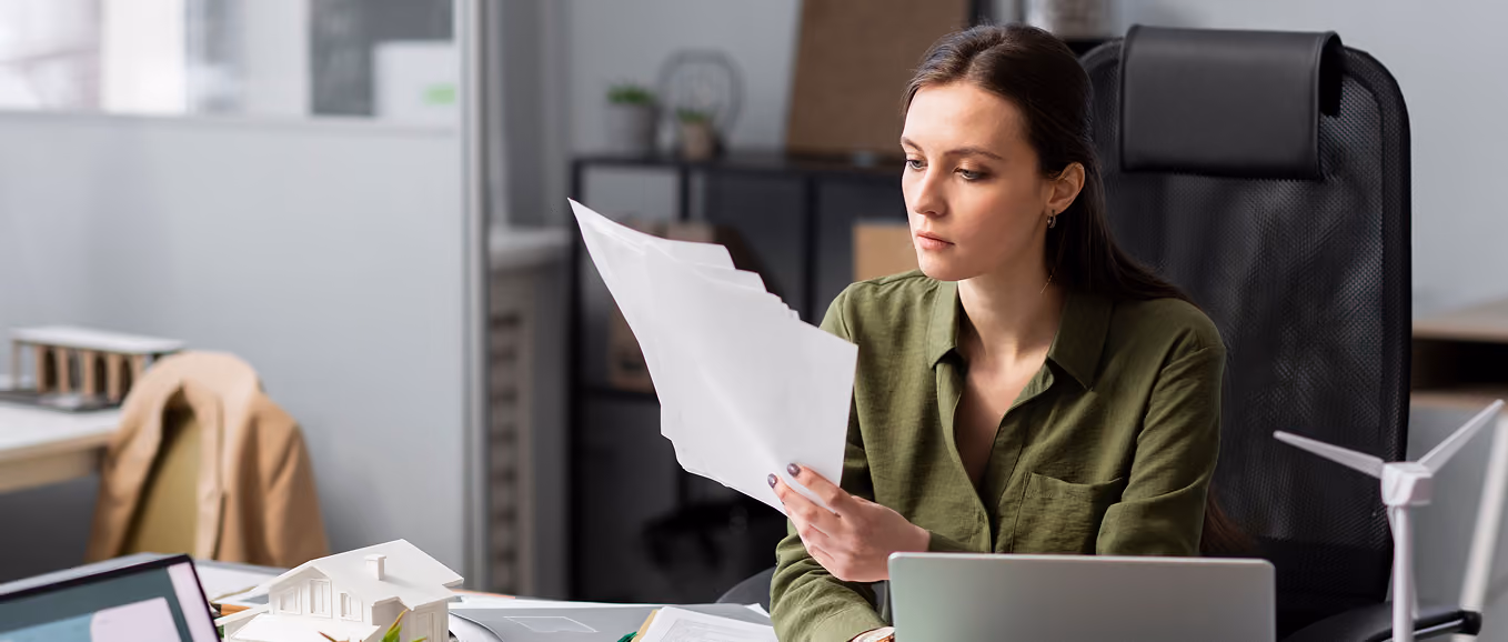 Finance employee reviewing paper documents that an ERP system like XARPA ERP replaces