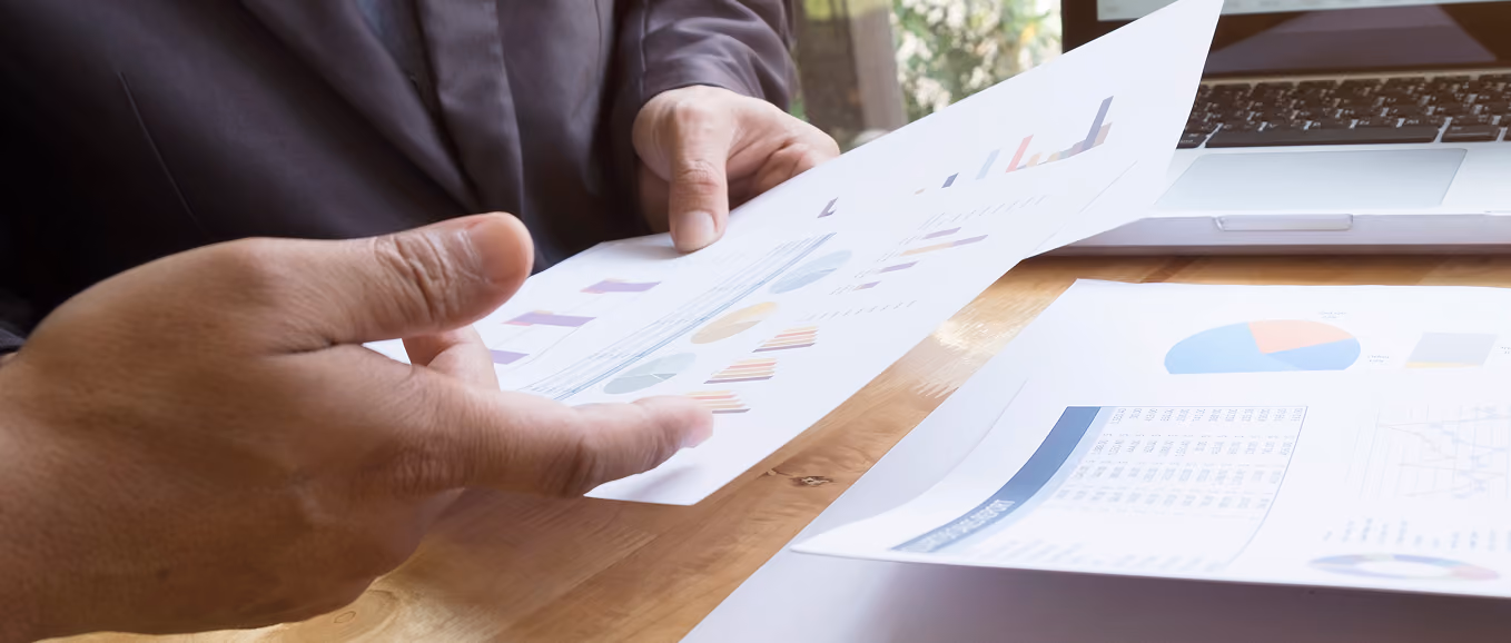 Printed reports and charts showing work that custom business software can automate
