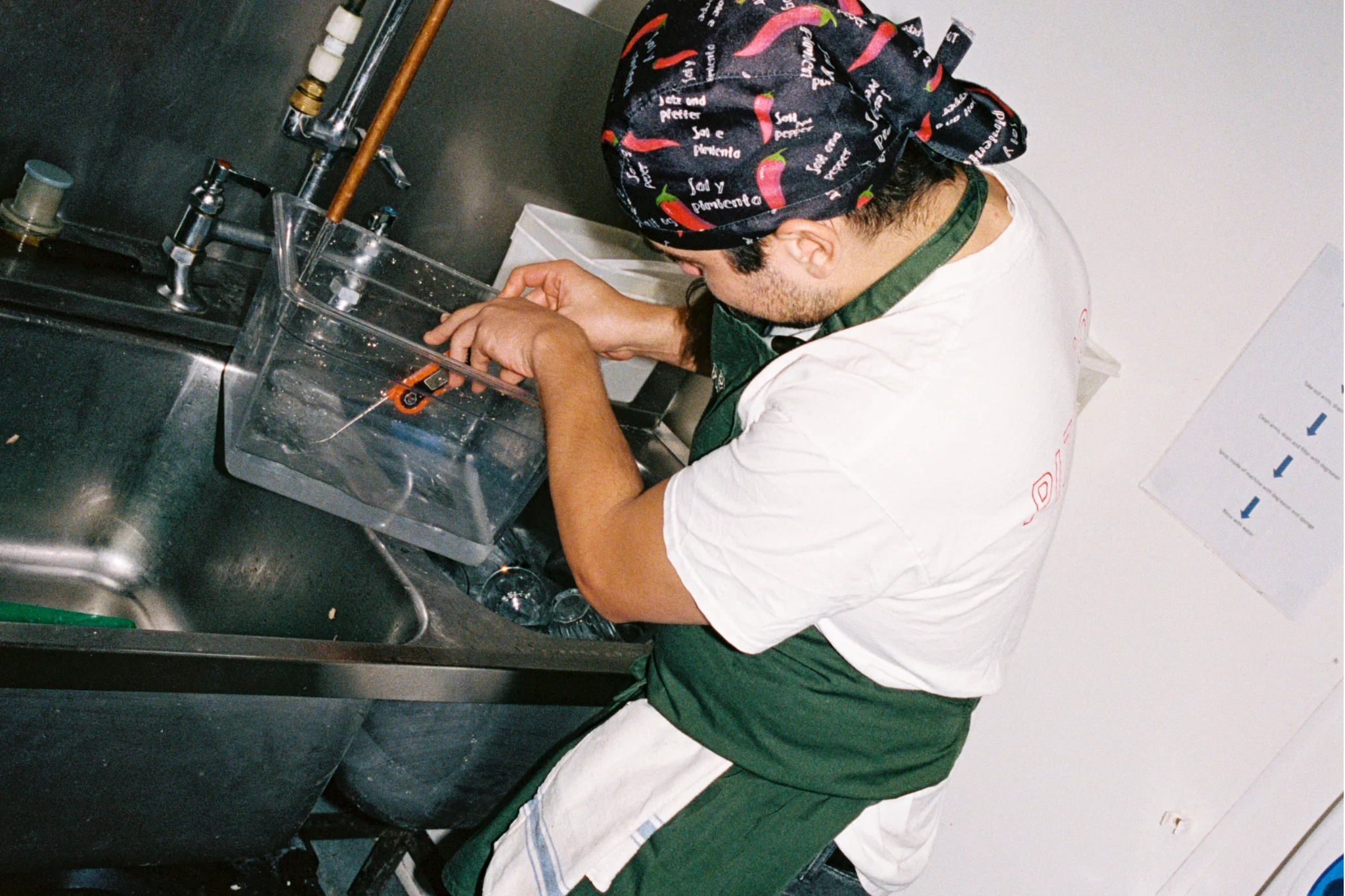 Restaurant employee testing water temperature in the kitchen