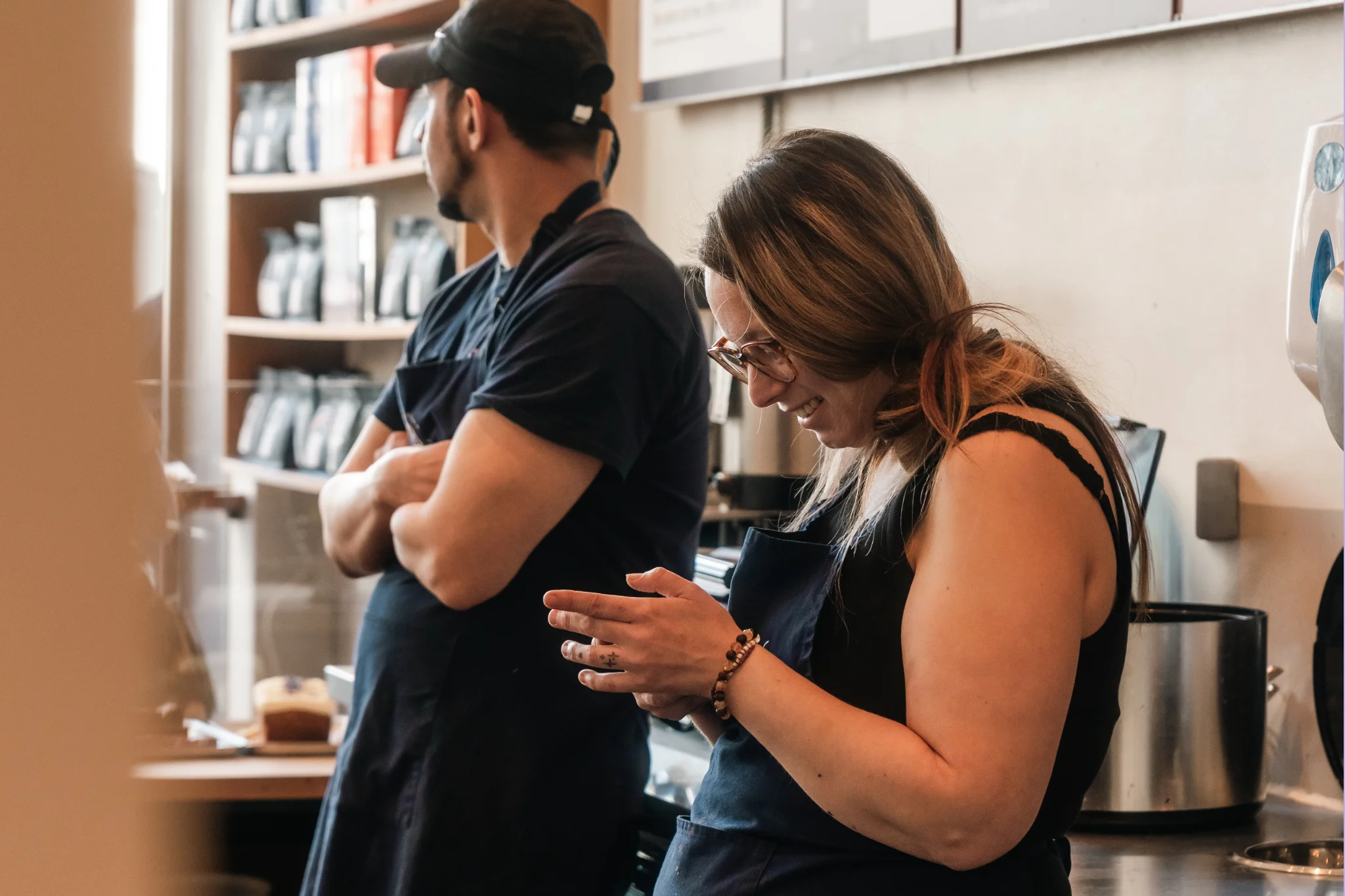 Two baristas stood behind the checkout