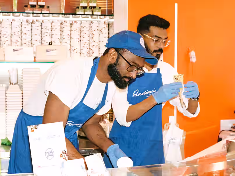 Two restaurant staff members checking ingredients using Nory AI system in a vibrant kitchen.