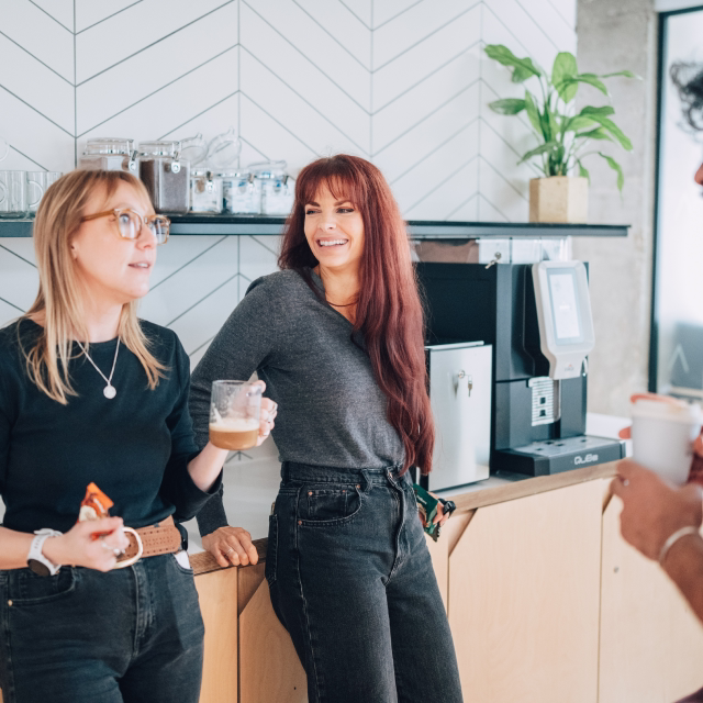 Nory team members chatting in the office kitchen