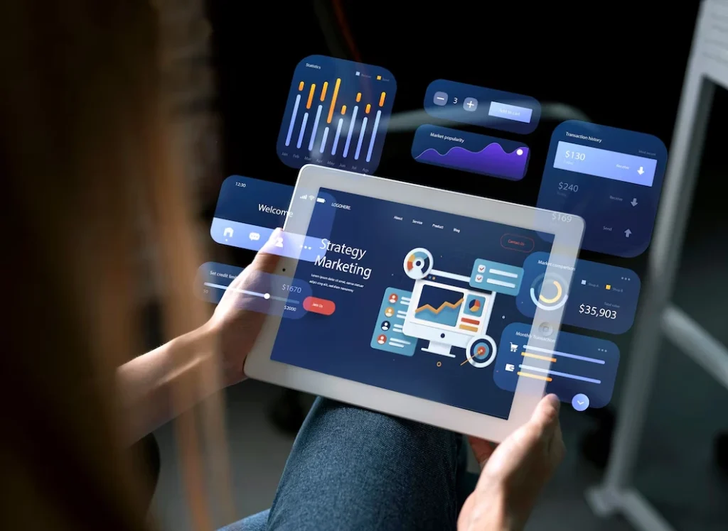 Person holding a tablet displaying a digital marketing analytics dashboard, with floating UI panels showing charts, sales figures, cart controls, and performance metrics.