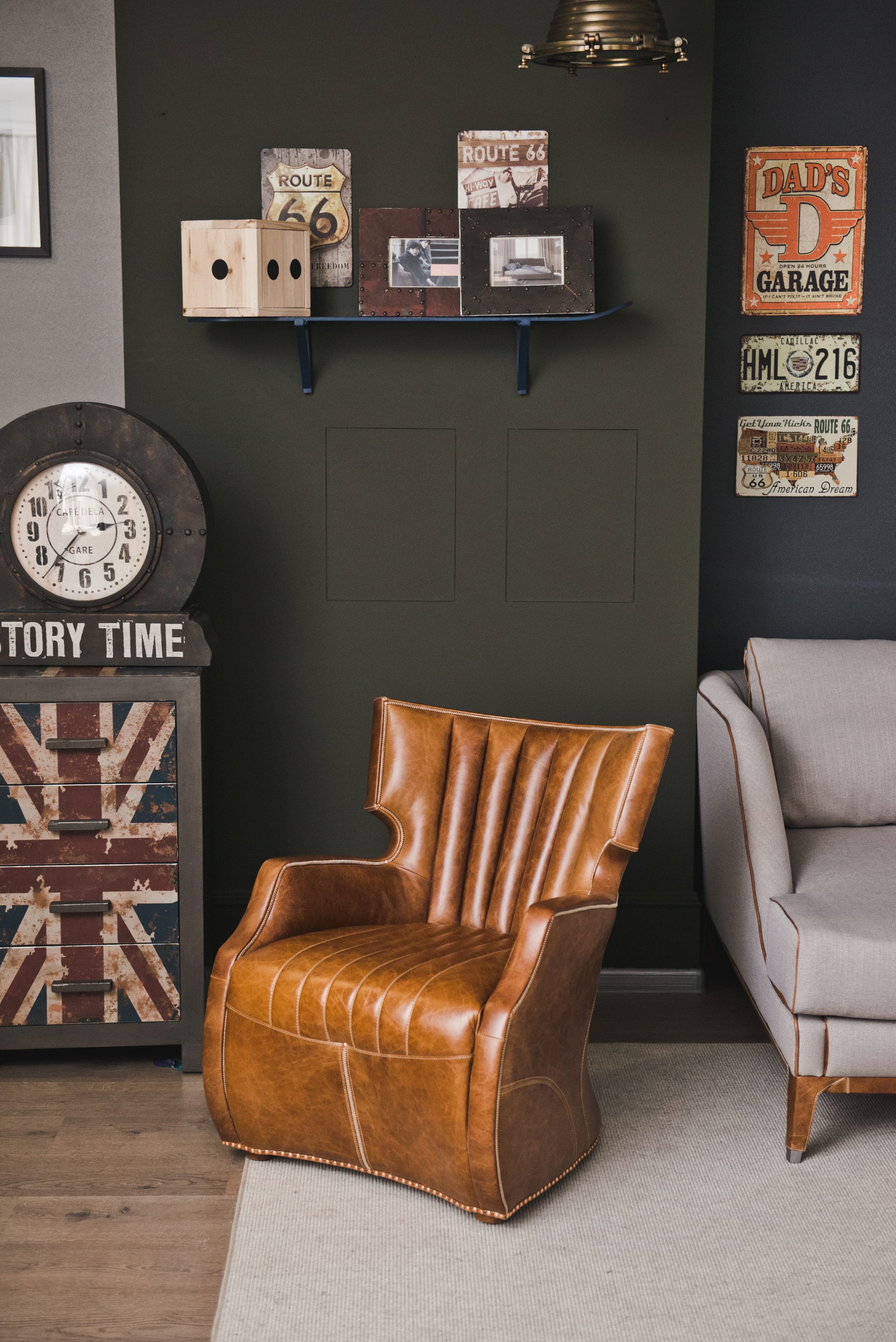 Brown leather armchair in a living room with vintage signs and a large clock on the wall.