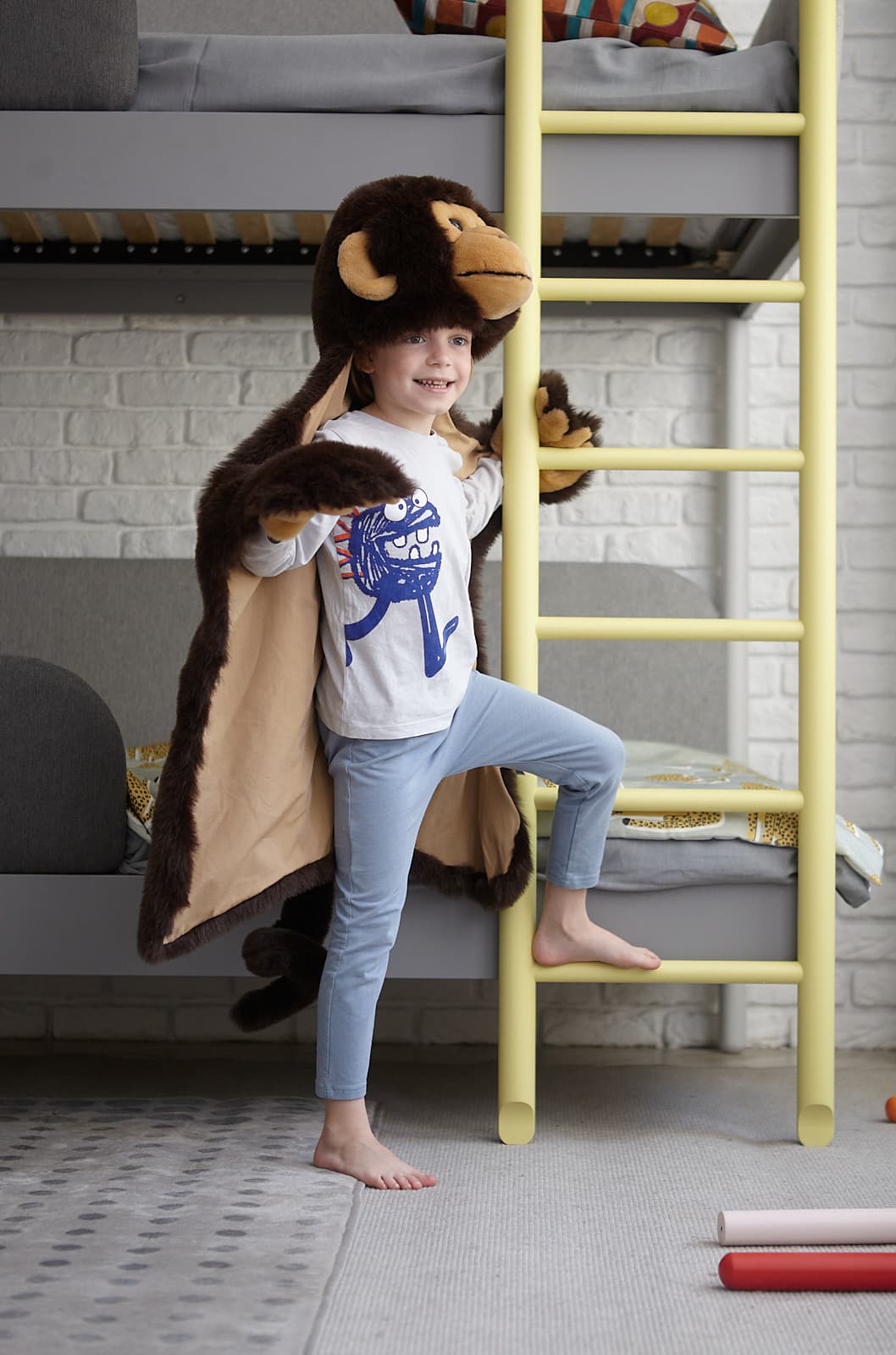 boy in superhero costume in children's room
