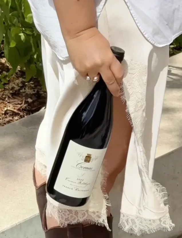 Person carrying a bottle of wine