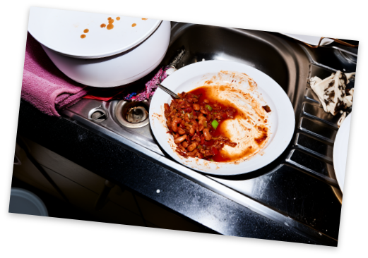 Leftover food scraped into a bowl in the sink