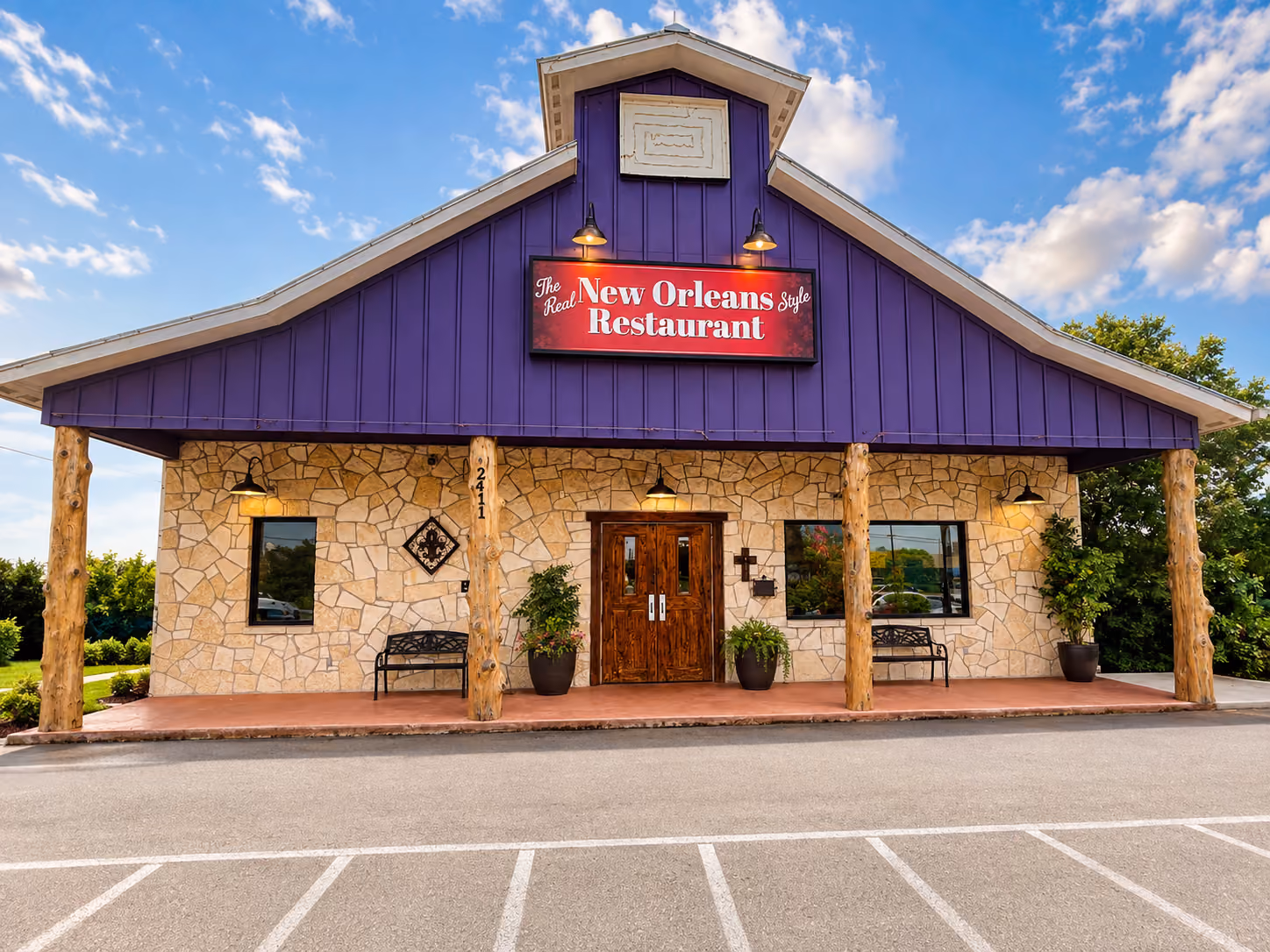 Stone facade with wooden door and purple roof of The Real New Orleans Style Restaurant building.