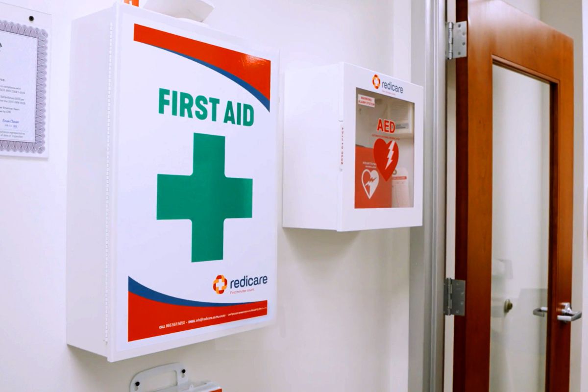 A first aid cabinet mounted in a workplace breakroom