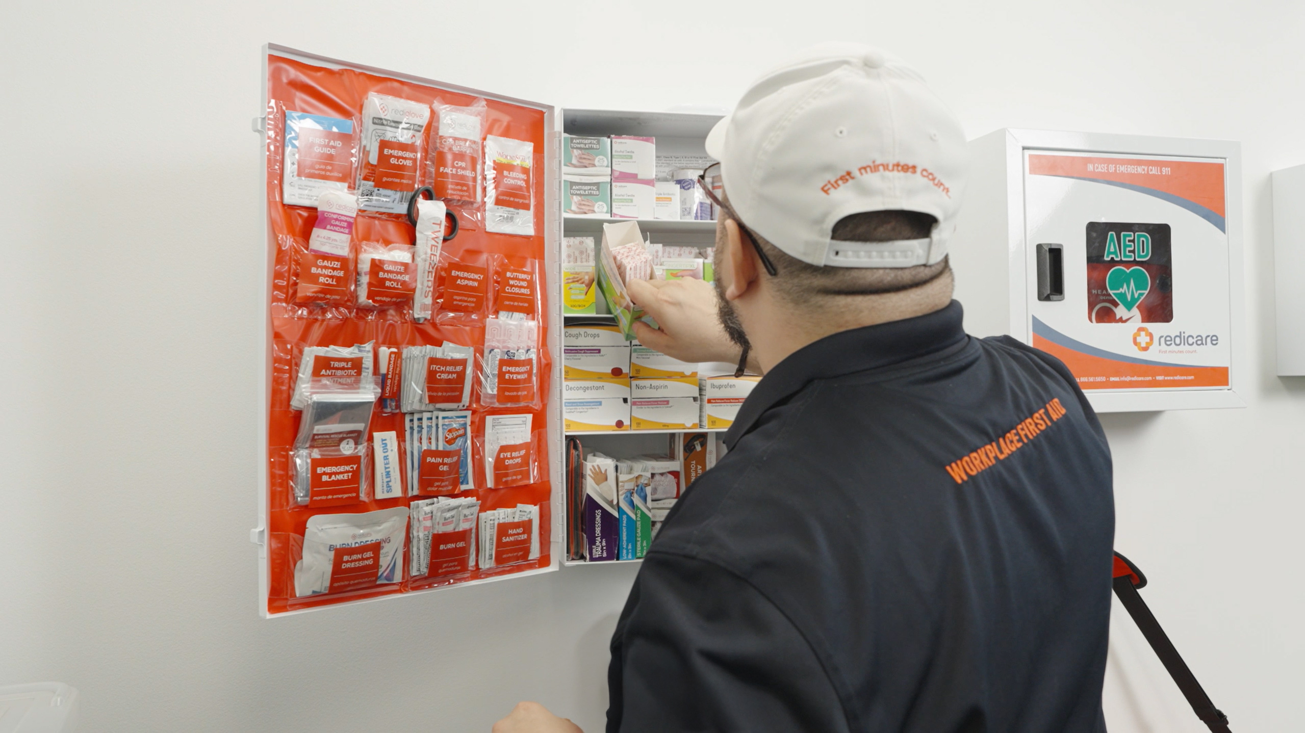 A Redicare representative restocking bandages in a first aid cabinet