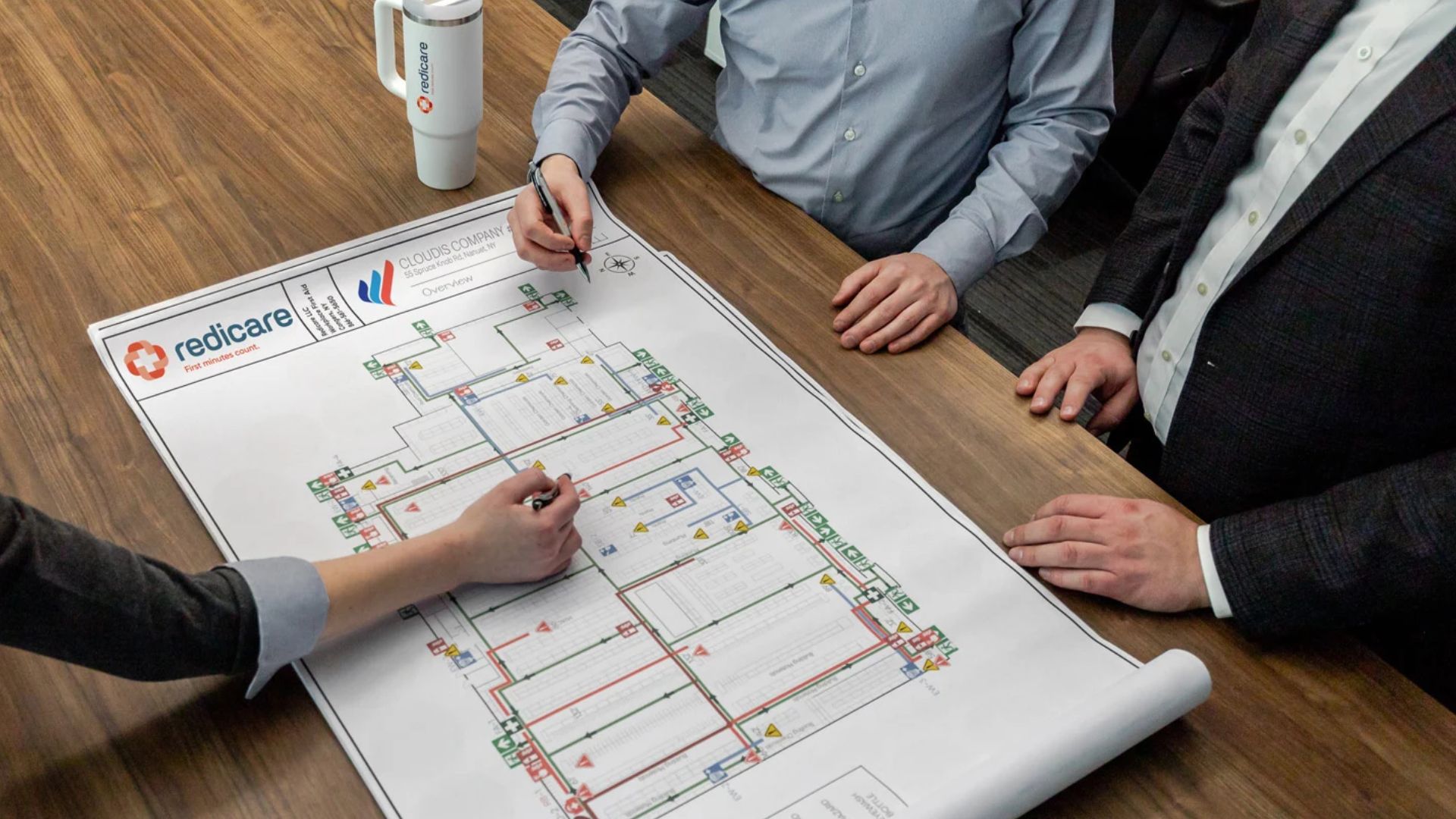 Three people working on a paper draft of an evacuation plan
