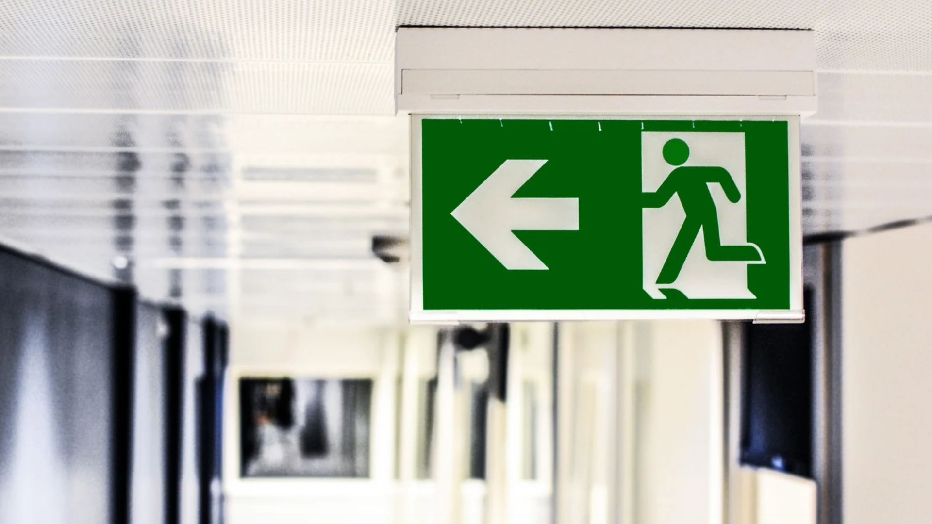 A green exit sign mounted to the ceiling
