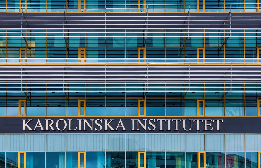 Facade of the Karolinska Institutet building with blue tinted windows and yellow window frames.