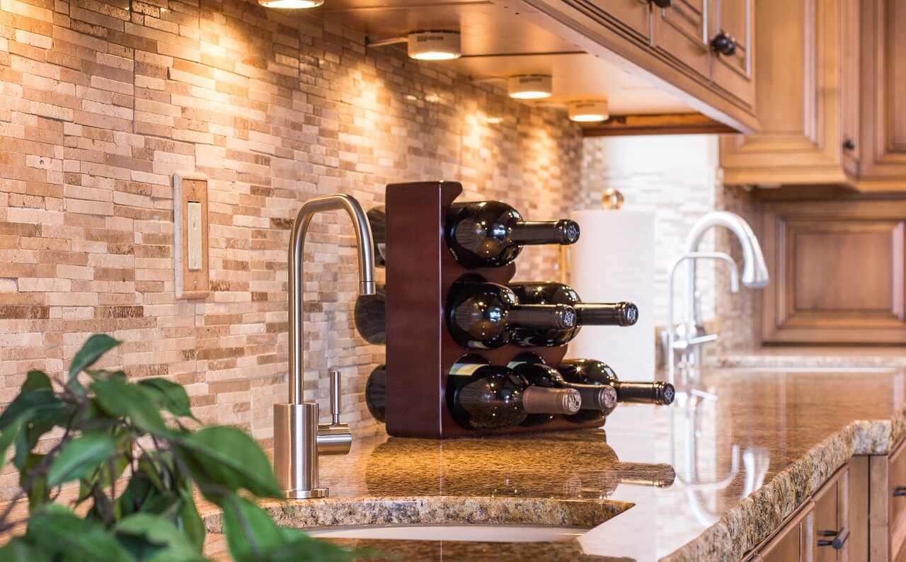 A wall-mounted wine rack holding bottles on a home kitchen counter
