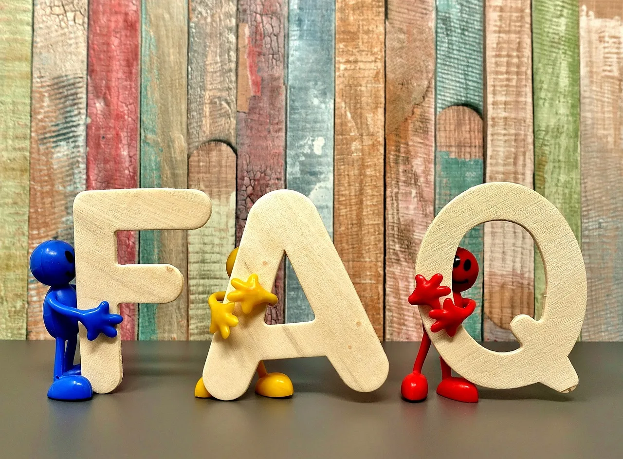 Wooden FAQ letters standing against a wall of painted reclaimed wood