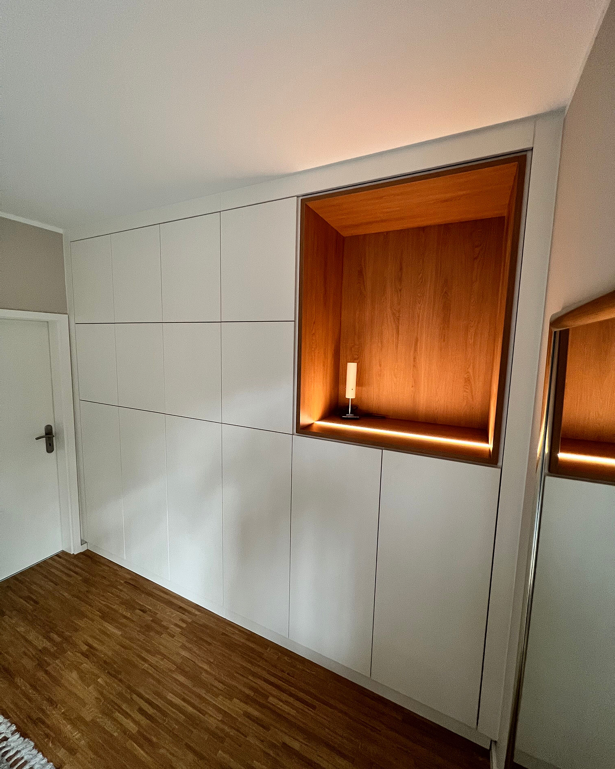Raumhoher Einbauschrank mit beleuchteter Holznische