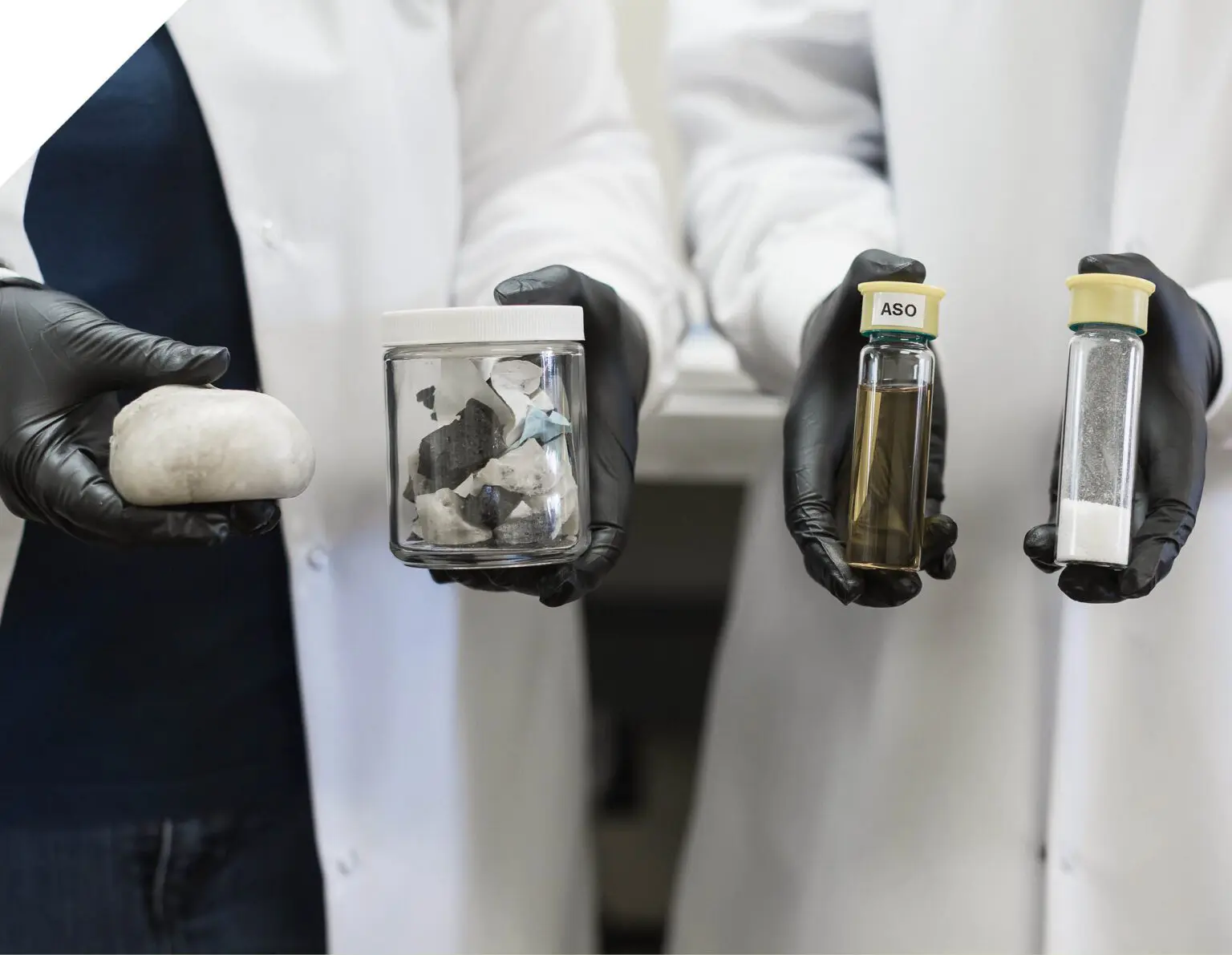 Gloved lab technicians holding polystyrene waste samples and vials of recycled styrene monomer oil and powder