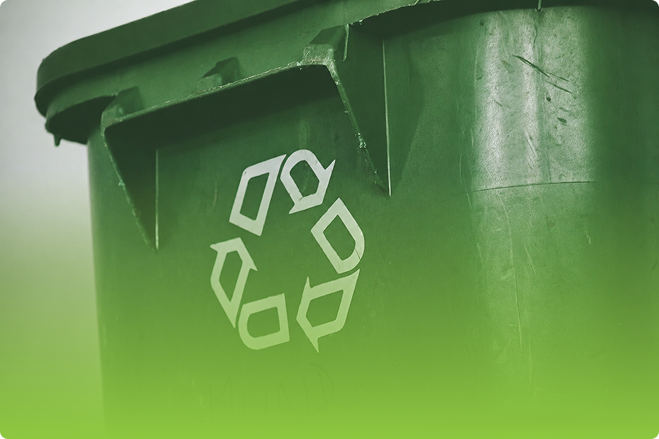 Close-up of a green recycling bin with the recycling symbol on its lid