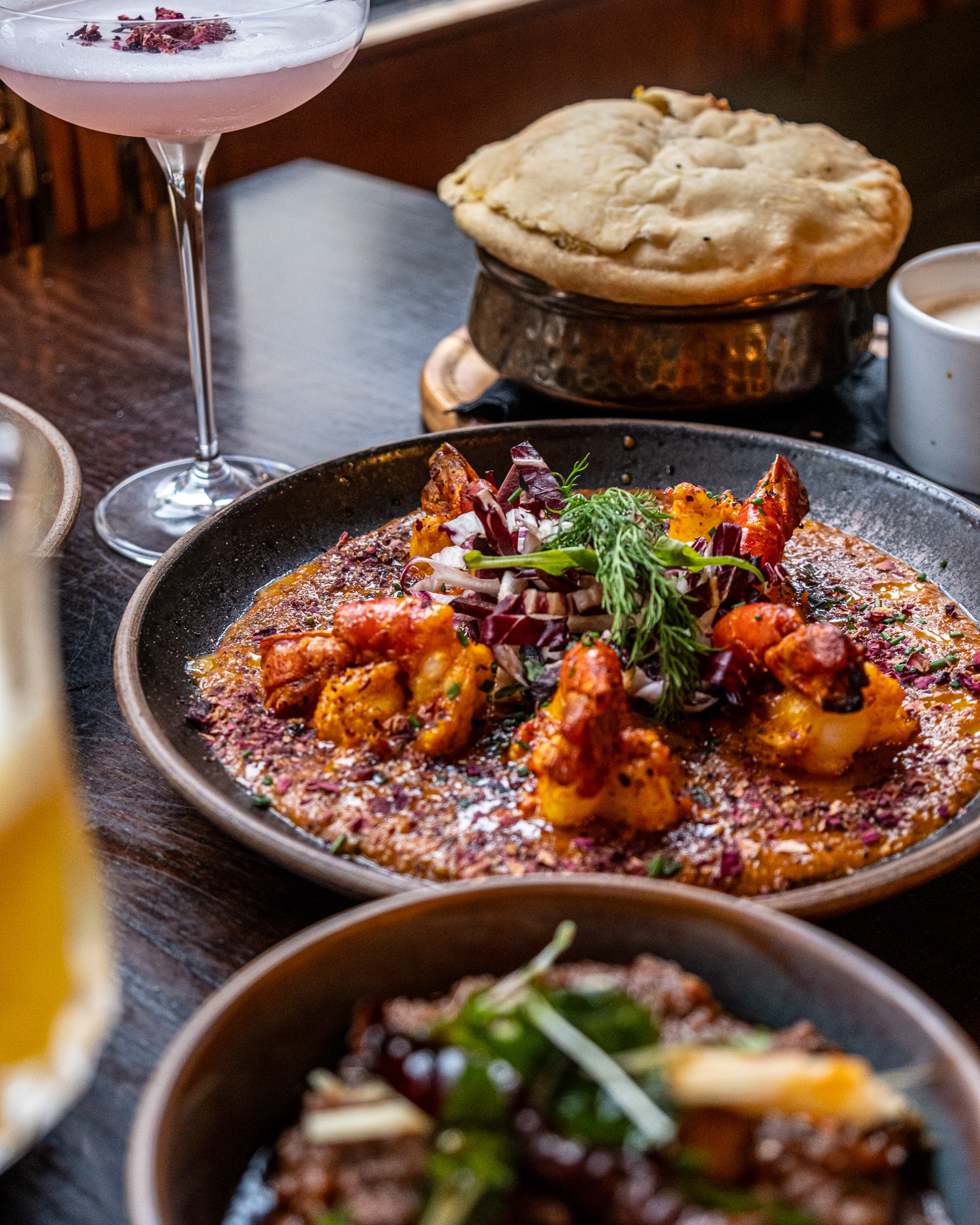 A rich prawn curry surrounded by Indian dishes at Nutmeg