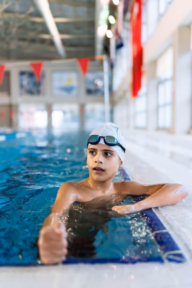 Boy resting at the edge of the pool.