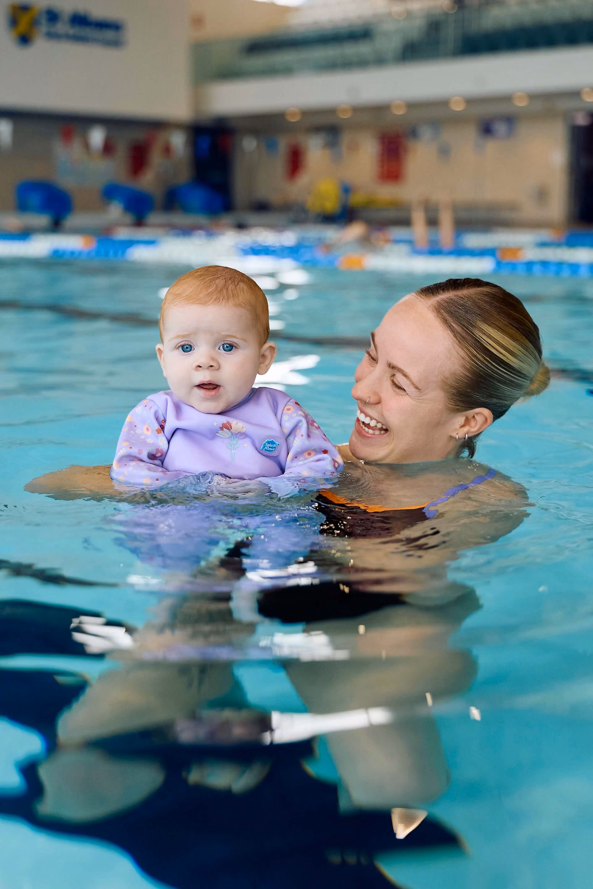 Woman swimming with young child.