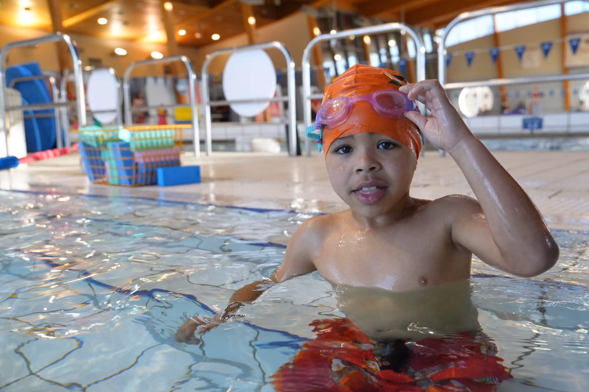 Young boy wading in the water.