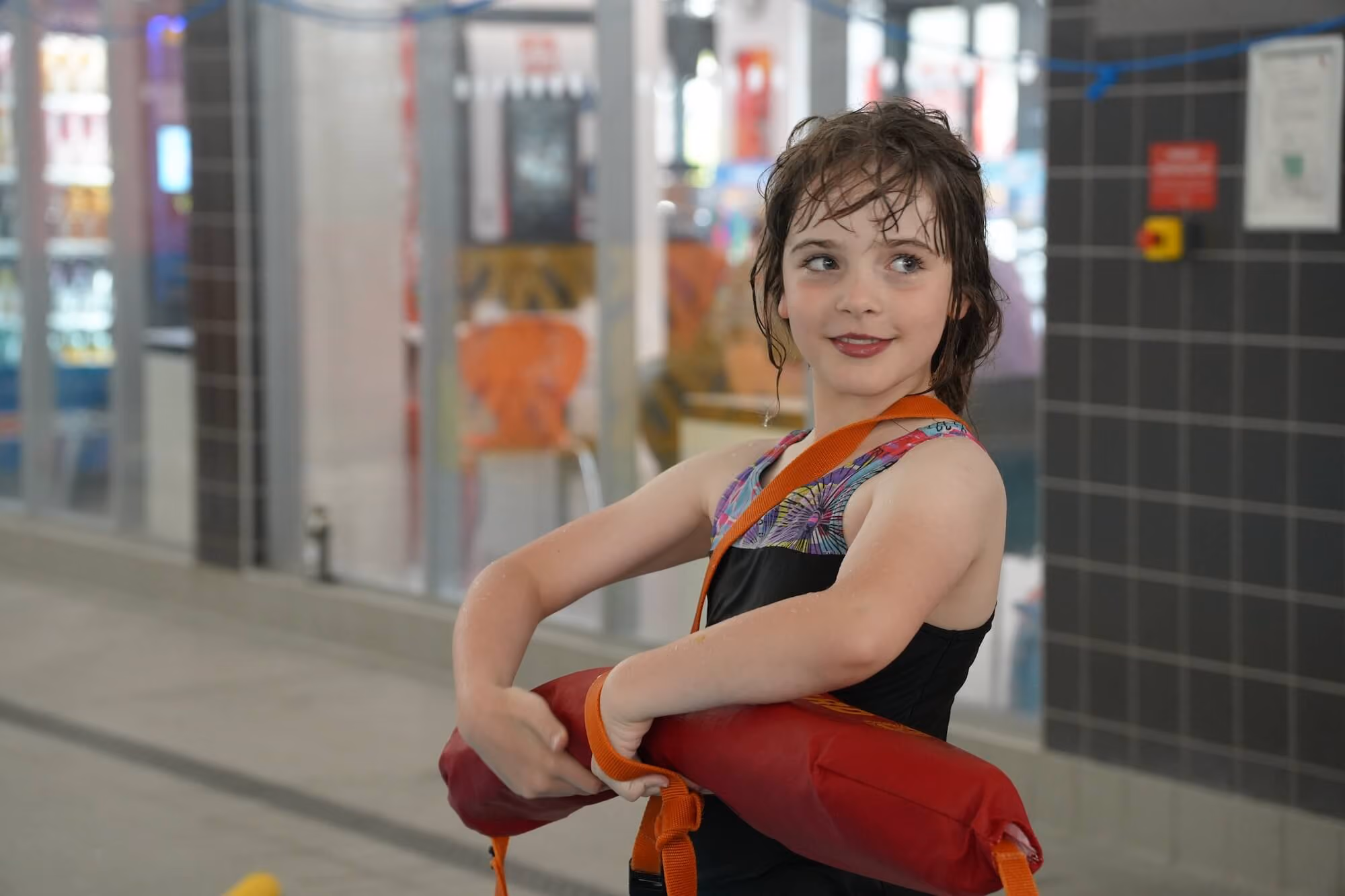Young girl with a life guard flotation device.