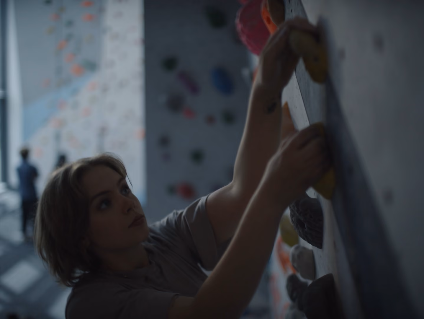 Woman on a indoor rock climbing wall.