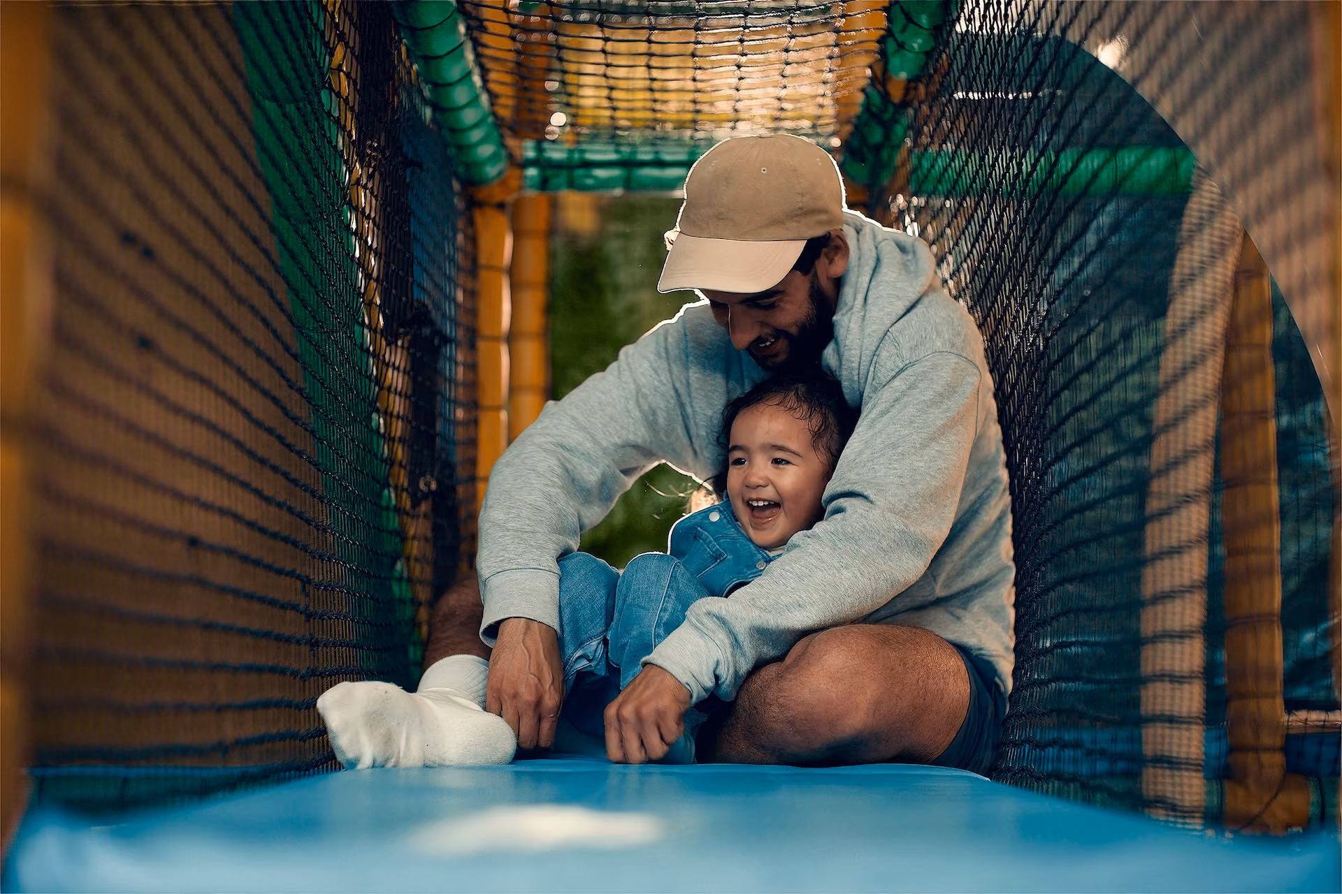 Father playing with his daughter in play place.