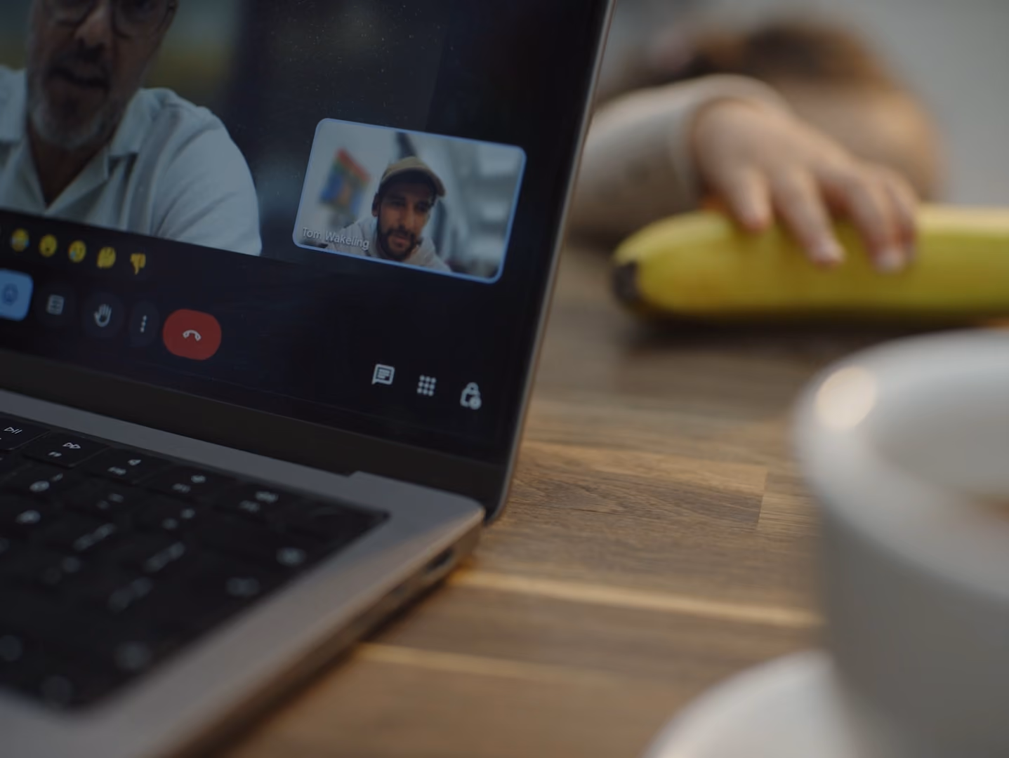 Man on a zoom call while child plays in the background.