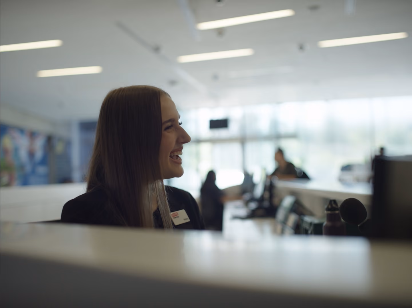 Everyone Active employee smiling from desk.