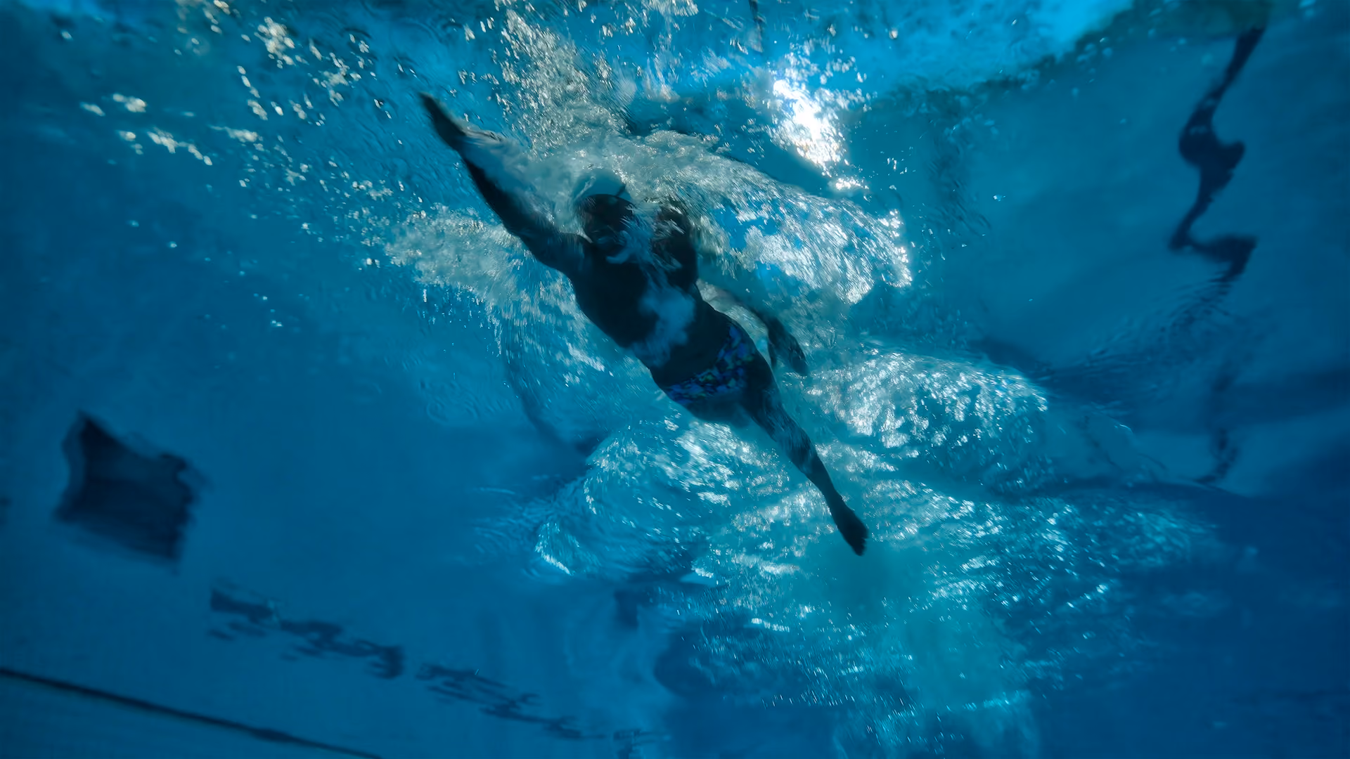 Person swimming laps from underwater.