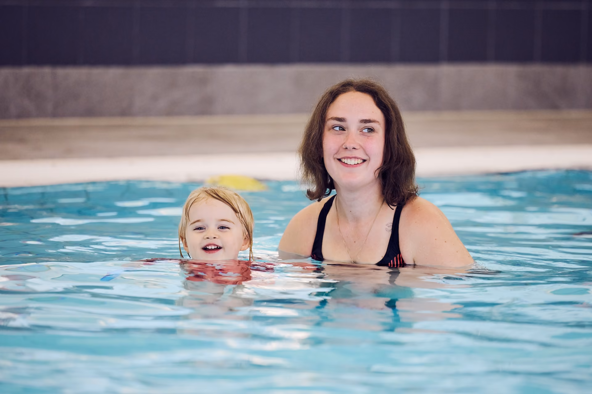 Woman and toddler in a pool.