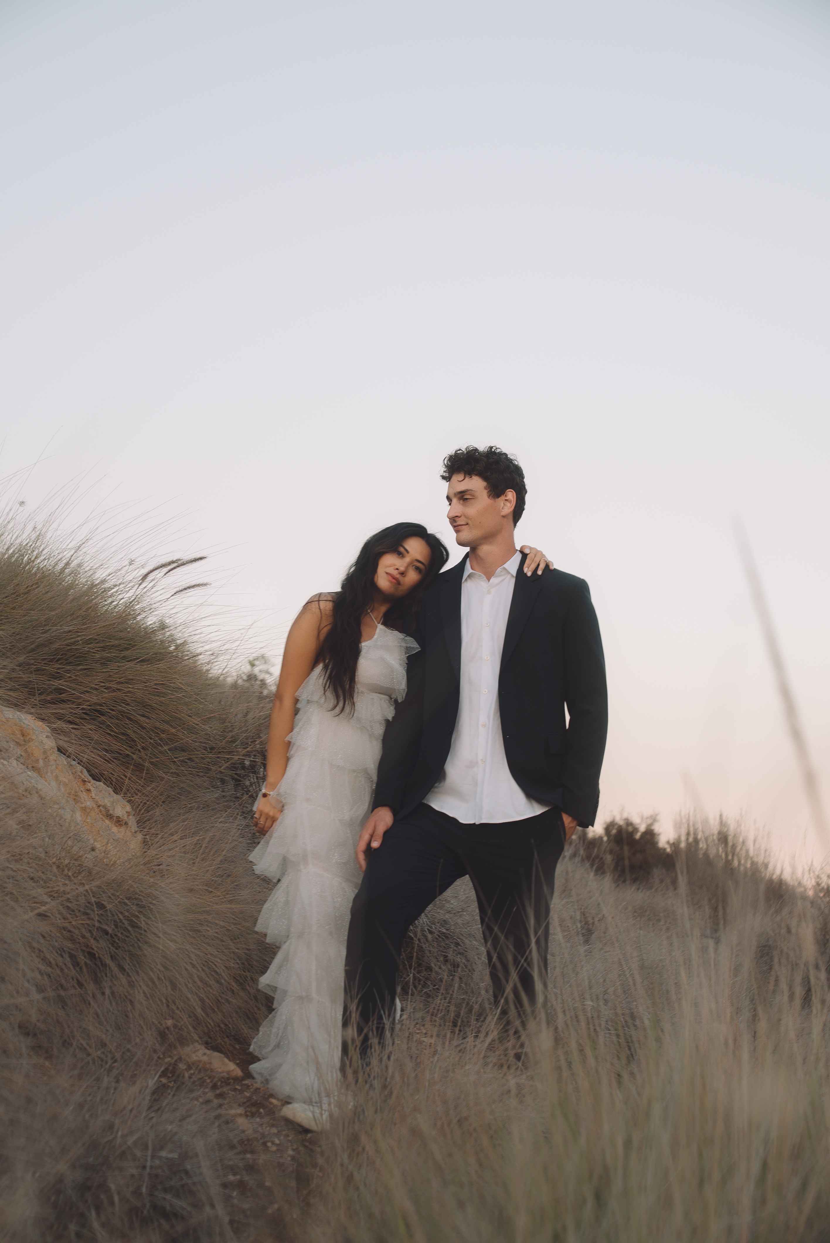 Couple on a grassy hillside at twilight