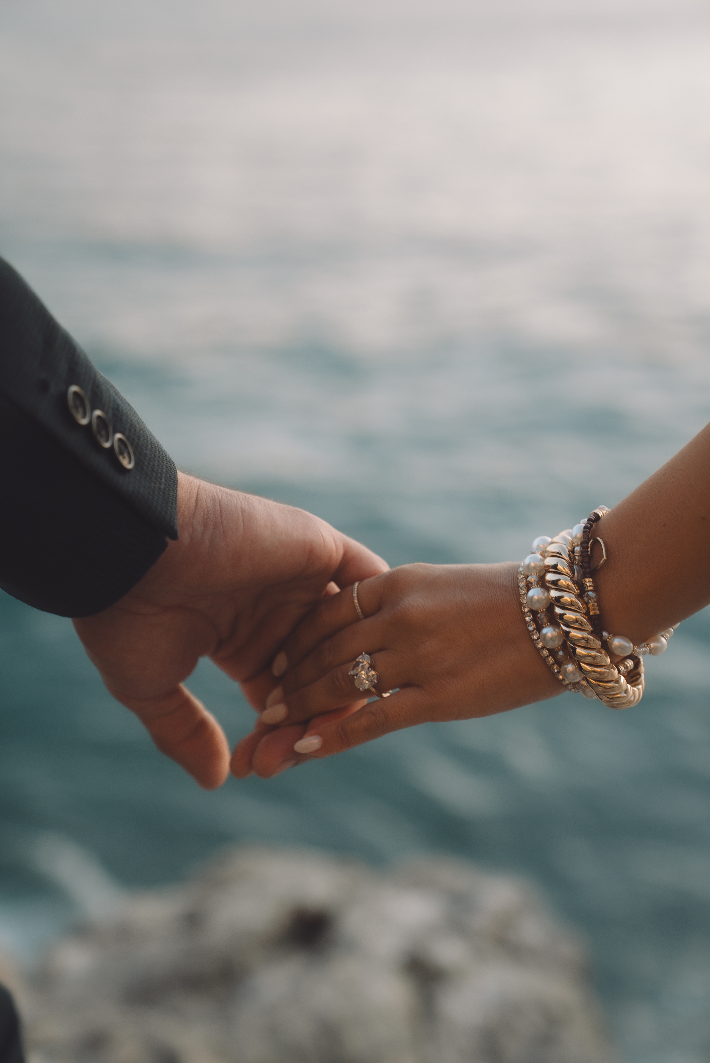 Couple holding hands above the ocean