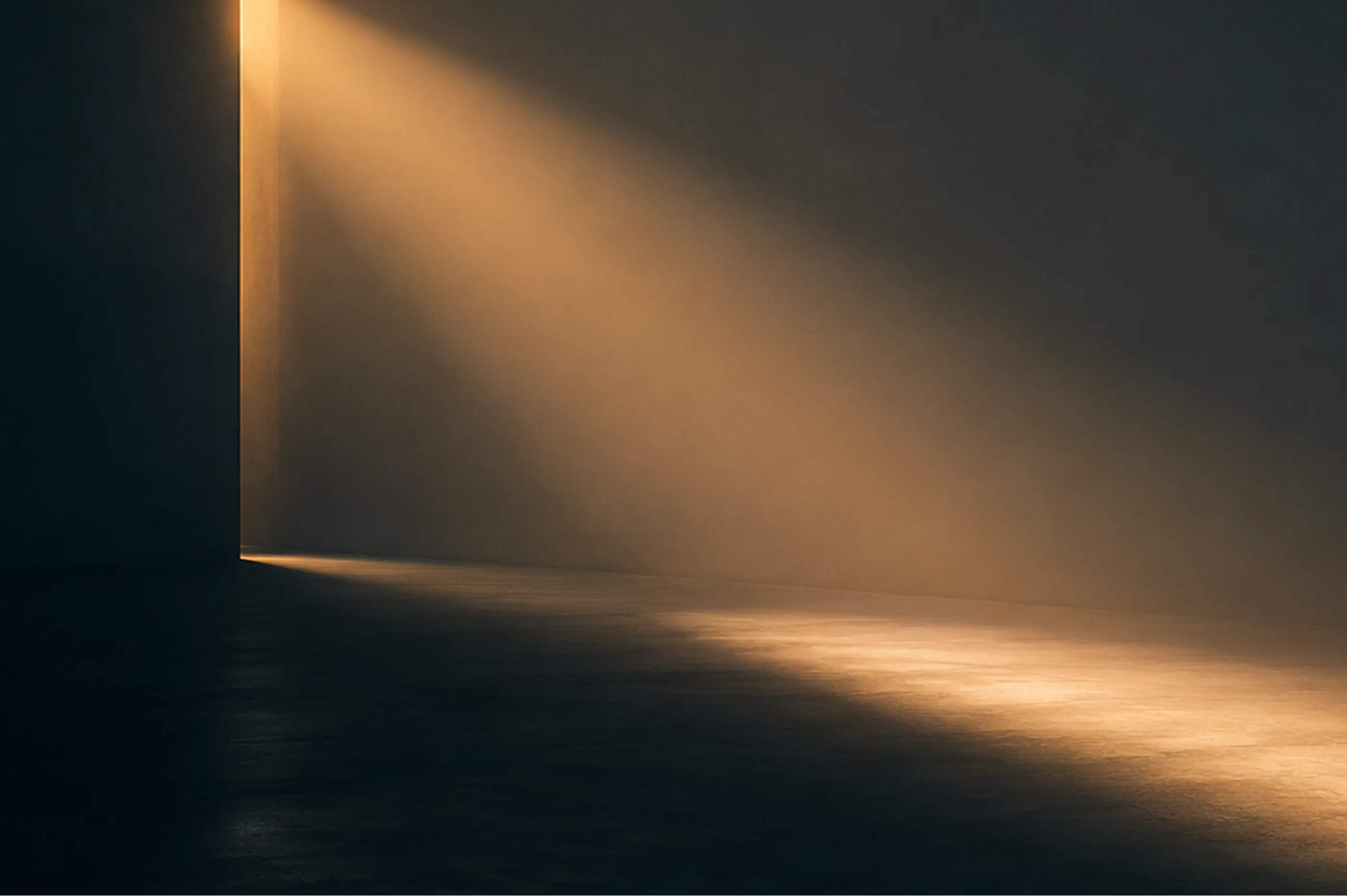 Minimalist dark interior space lit by a striking beam of golden sunlight streaming through a doorway
