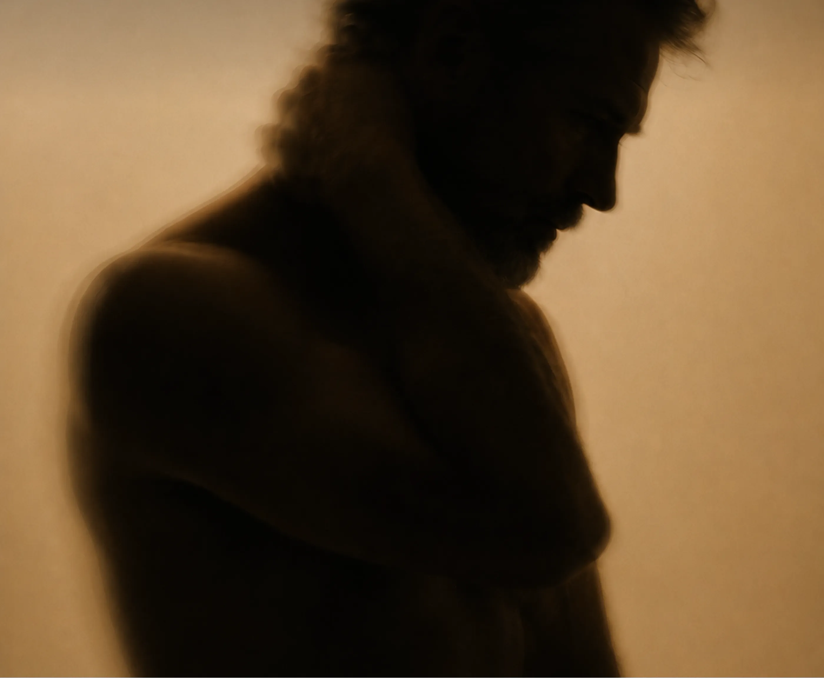 Soft-focus, warm-toned silhouette of a athletic person in side profile