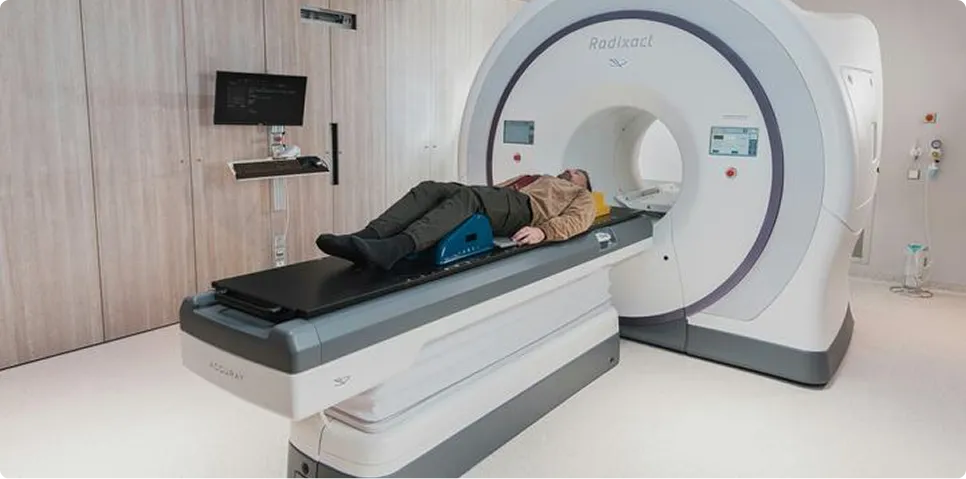 Modern CT scanner machine in a bright, high-tech clinical examination room