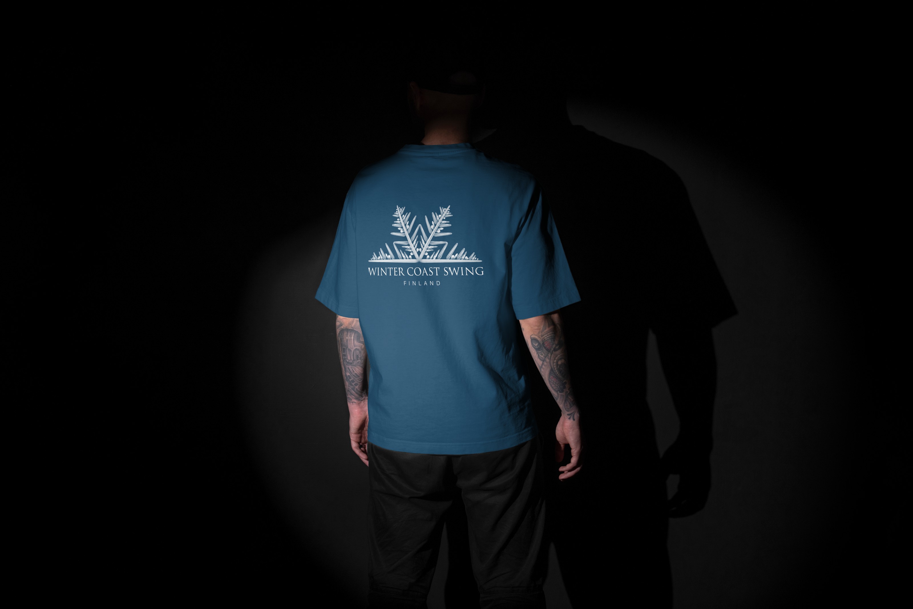 Winter Coast Swing primary lockup on a blue T-shirt