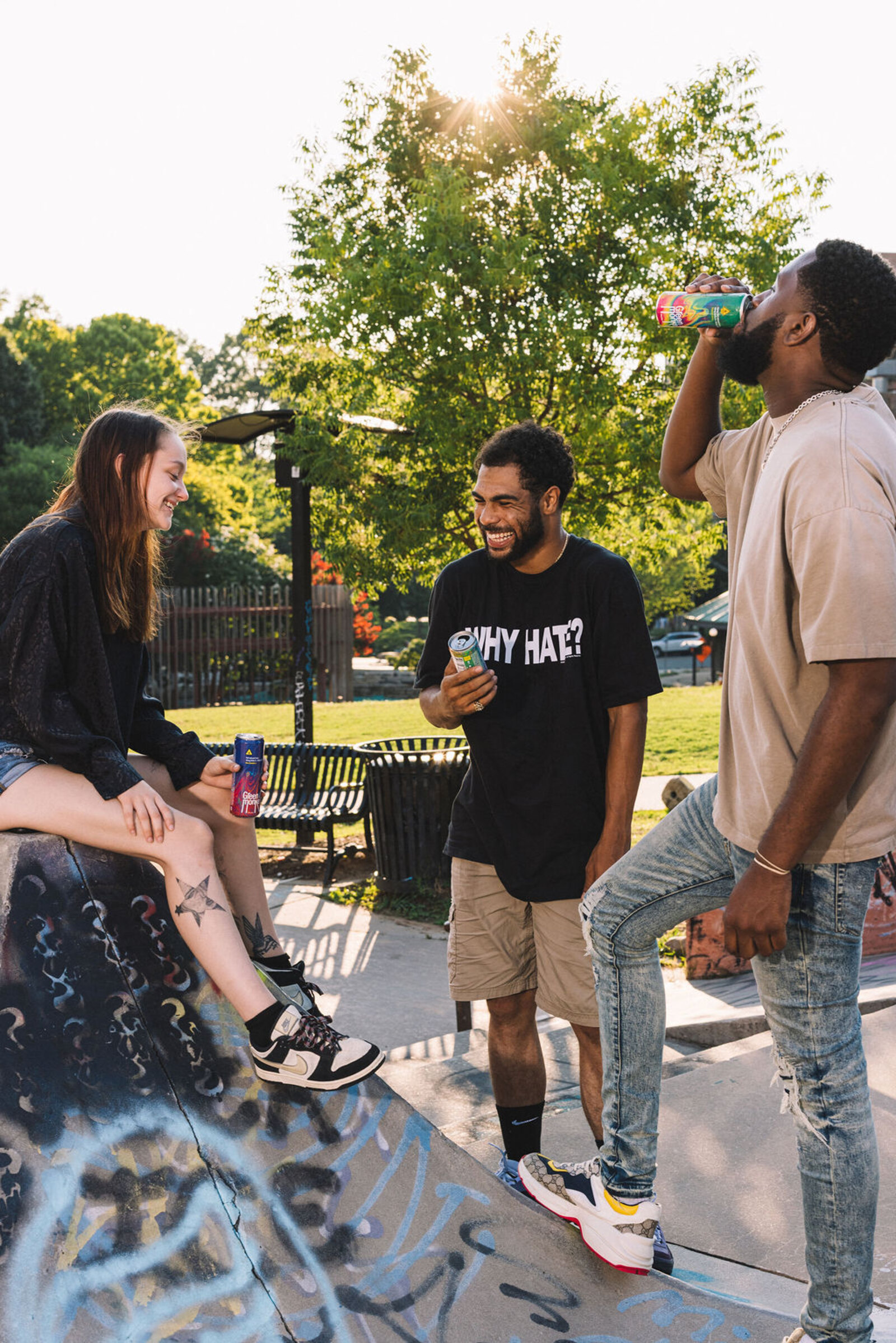 Friends laughing together at a skatepark holding cans of Green Monké