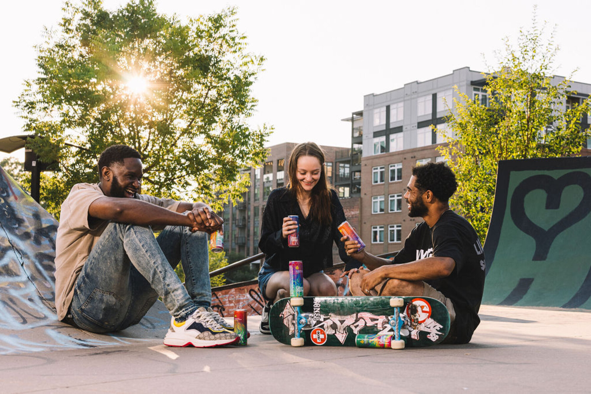 Friends sharing Green Monké at a skatepark at golden hour