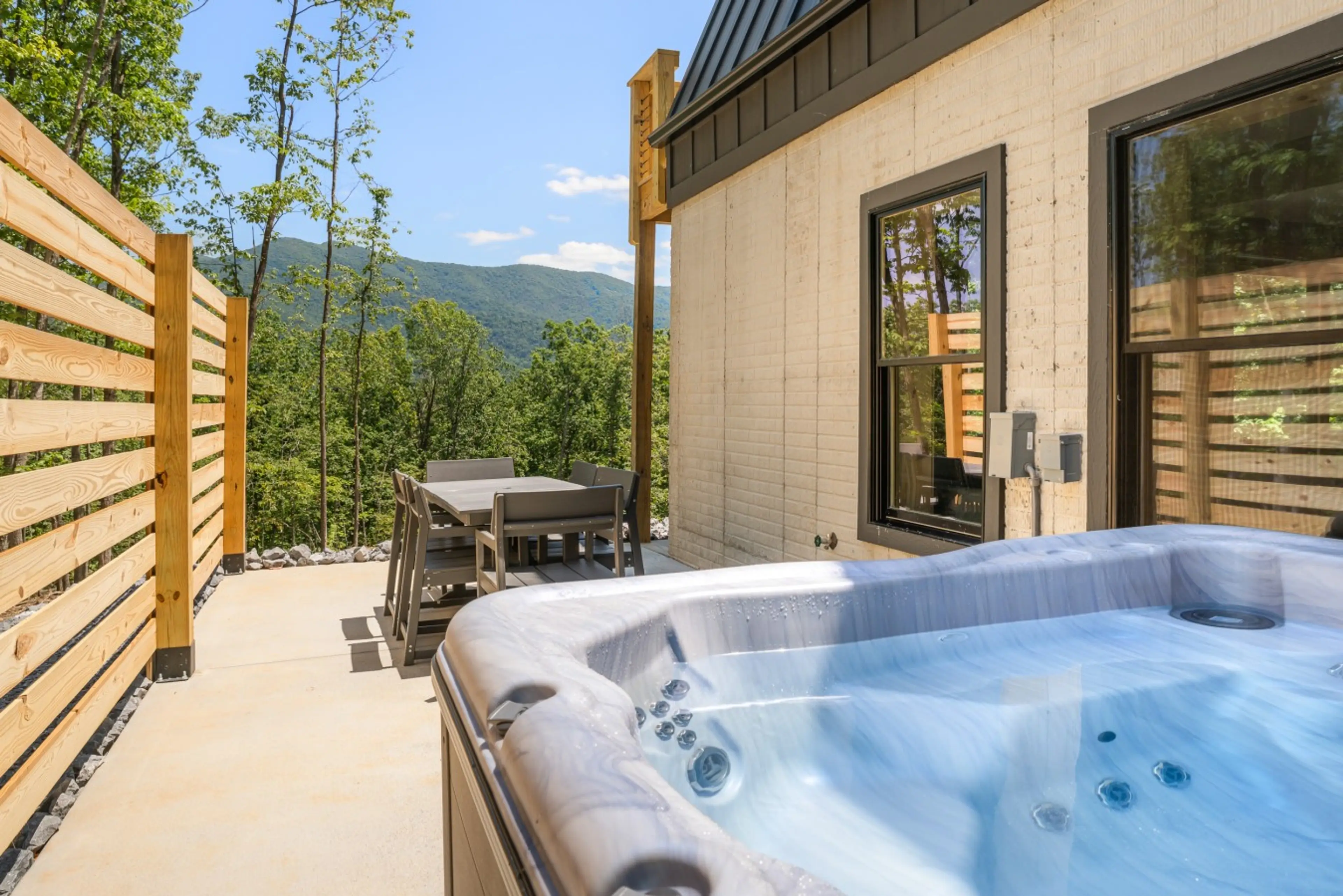 Private hot tub on the deck at Solhaus Shenandoah with a wood privacy fence