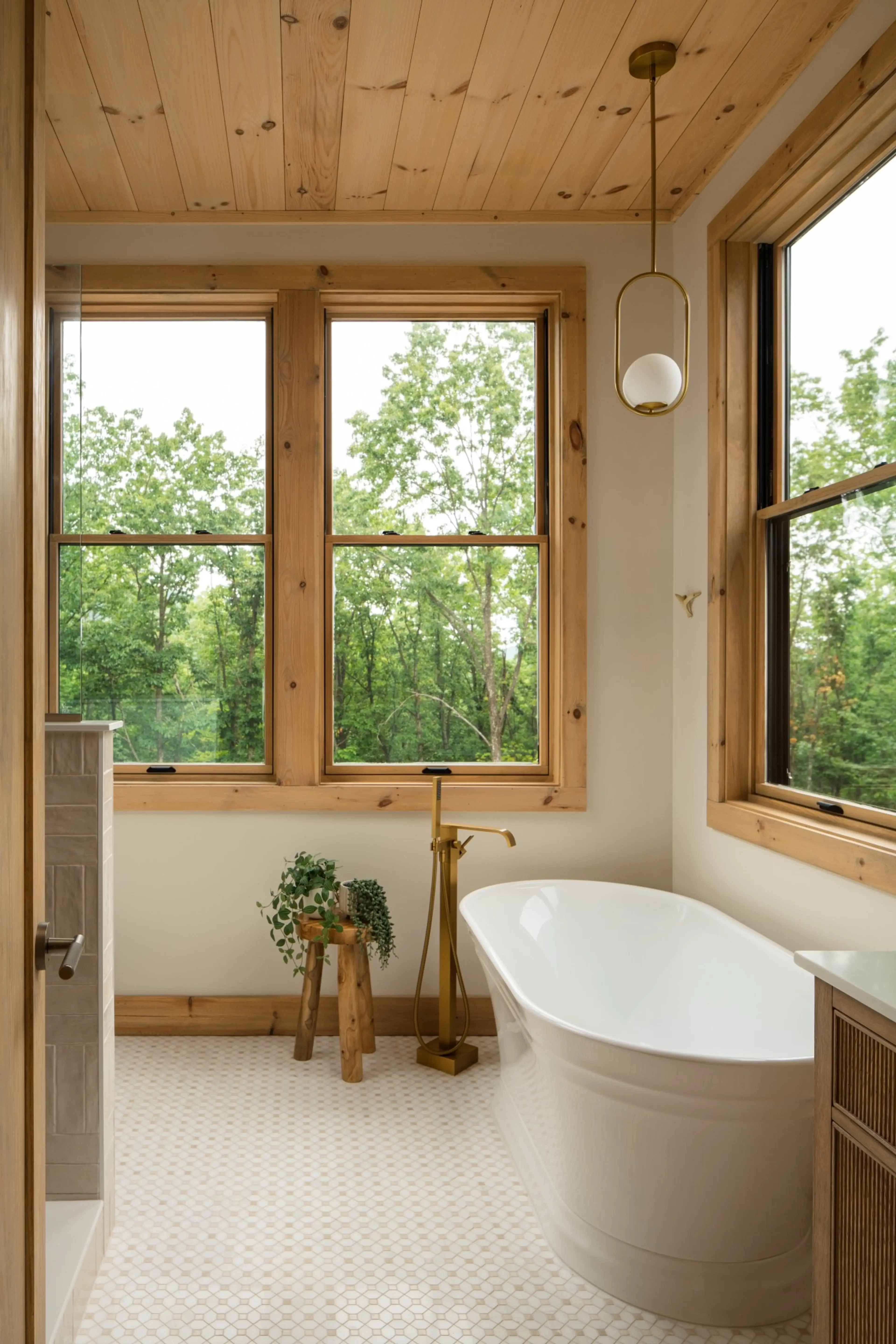 Freestanding soaking tub by the window in a Solhaus Shenandoah bathroom