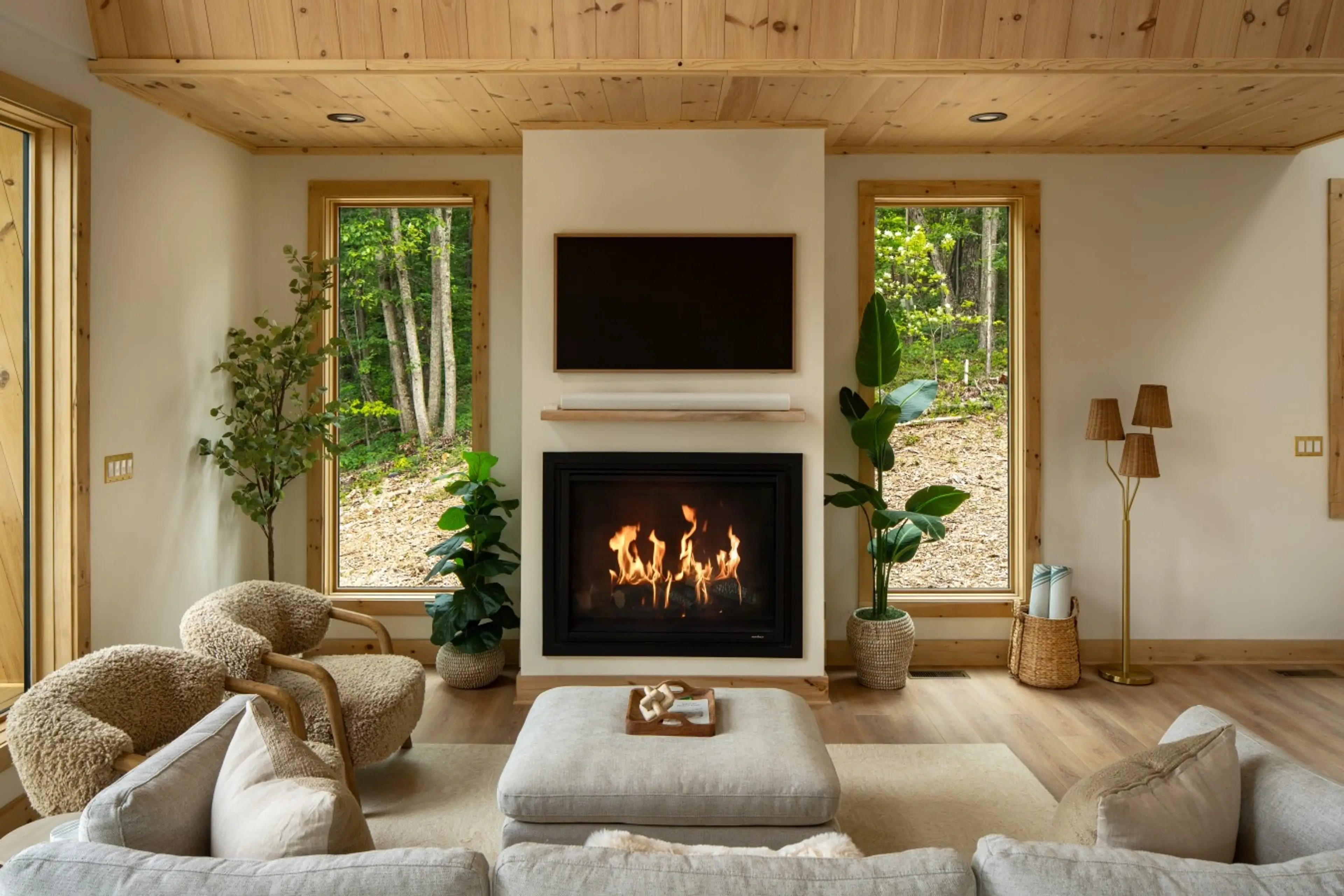 Living room at Solhaus Shenandoah with a lit fireplace and mountain view through the window
